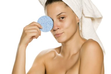 Beyaz arka planda sünger pedi ile poz veren güzel bir kadın.