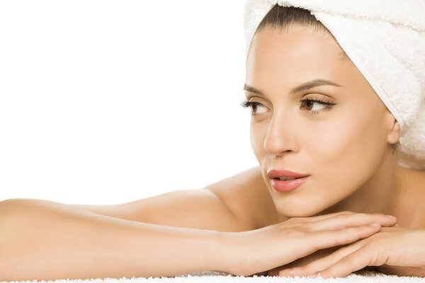 Young beautiful woman with towel on her head on white background