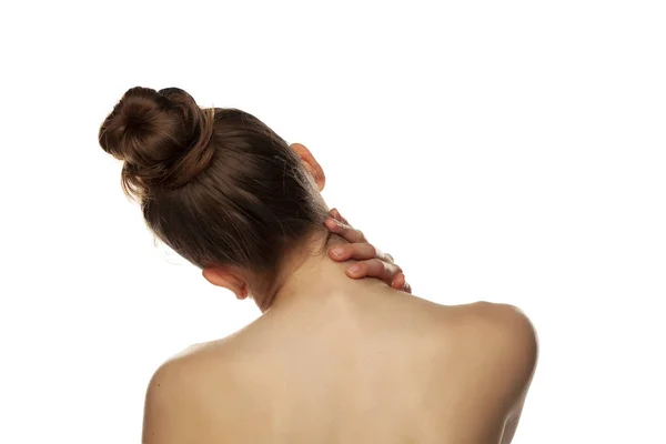 Young tired woman touches her neck on white background — Stock Photo, Image