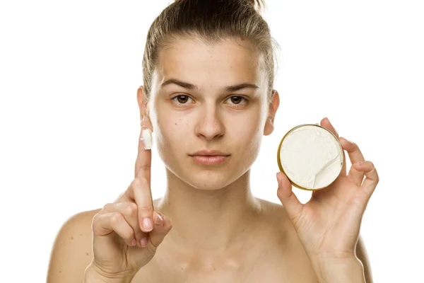 Retrato Mujer Joven Mostrando Crema Facial Con Dedo Sobre Fondo — Foto de Stock