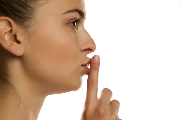 Junge Frau Mit Finger Auf Den Lippen Auf Weißem Hintergrund — Stockfoto