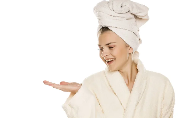 Młoda Piękna Kobieta Ręcznikiem Głowie Trzymająca Wyimaginowany Przedmiot Dłoni Białym — Zdjęcie stockowe