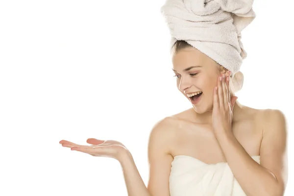 Młoda Piękna Kobieta Ręcznikiem Głowie Trzymająca Wyimaginowany Przedmiot Dłoni Białym — Zdjęcie stockowe