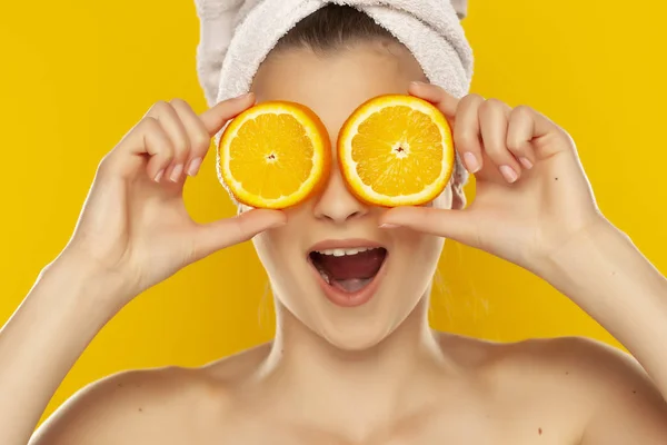 Young beautiful woman with towel on her head holding slices of o — Stock Photo, Image