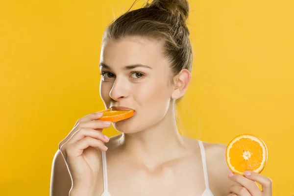 Portrait Young Beautiful Woman Eating Orange Yellow Background — Stock Photo, Image