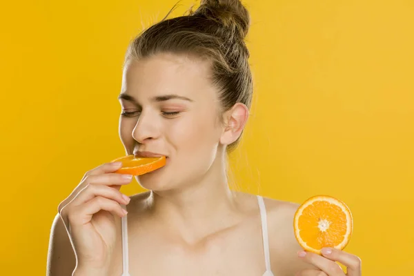 Retrato Jovens Shirtles Bela Mulher Comer Uma Laranja Fundo Amarelo — Fotografia de Stock