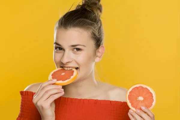 Young Beautiful Woman Eating Slices Grapefruit Yellow Background — Stock Photo, Image