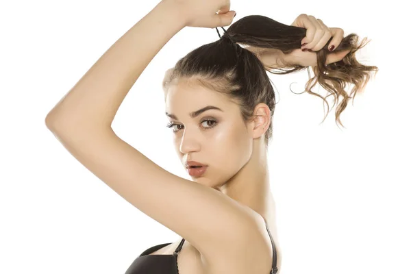 Jovem Com Maquiagem Amarrando Seu Cabelo Fundo Branco — Fotografia de Stock