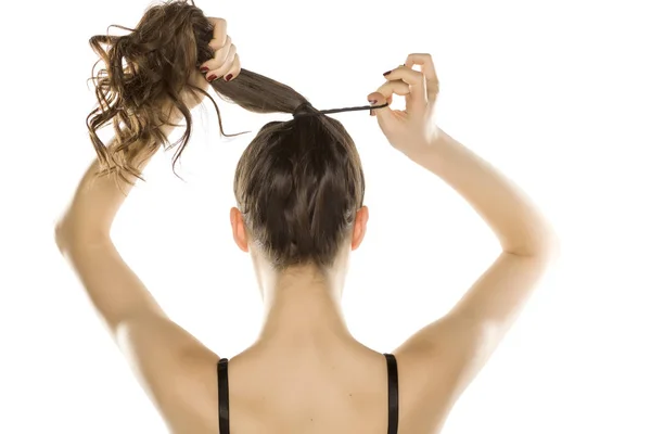 Jovem Mulher Por Trás Amarrando Cabelo Fundo Branco — Fotografia de Stock