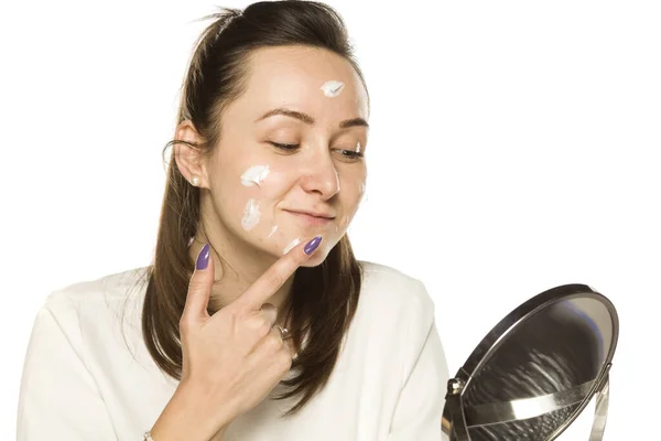 Una Mujer Que Aplica Crema Facial Sobre Fondo Blanco — Foto de Stock