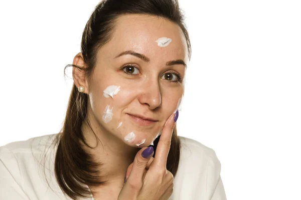 Una Mujer Que Aplica Crema Facial Sobre Fondo Blanco — Foto de Stock