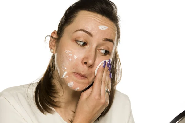 白い背景に綿のパッドで顔を掃除する女性 — ストック写真