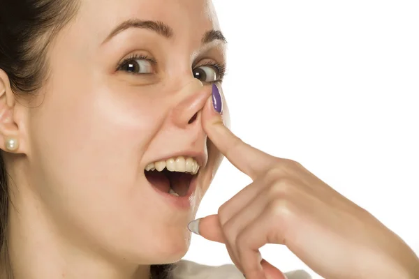 Gülen Komik Bir Kadın Beyaz Arka Planda Burnuna Dokunuyor — Stok fotoğraf