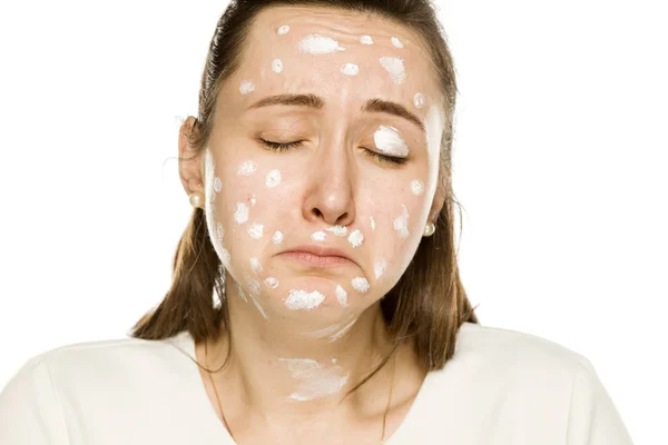 Mujer Infeliz Posando Con Crema Facial Sobre Fondo Blanco — Foto de Stock