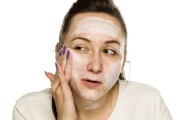 Mujer Divertida Aplicando Crema Facial Sobre Fondo Blanco — Foto de Stock
