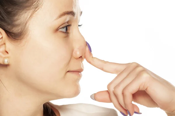 Een Glimlachende Vrouw Die Haar Neus Aanraakt Een Witte Achtergrond — Stockfoto