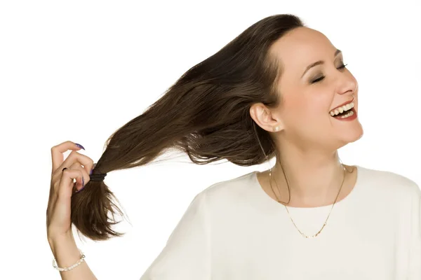 Jovem Mulher Feliz Tira Elástico Seu Cabelo Fundo Branco — Fotografia de Stock