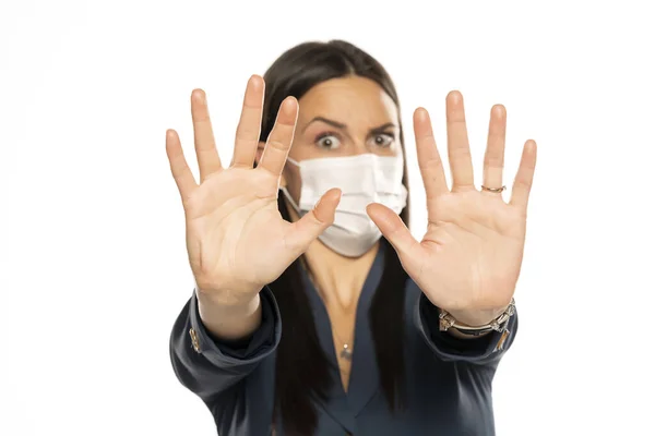 怒っている女性とともにストップ手と保護マスク上の彼女の顔上の白い背景 — ストック写真