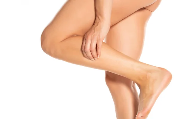 Frau Hält Ihr Schmerzhaftes Bein Auf Weißem Hintergrund — Stockfoto