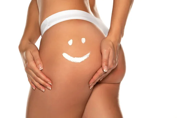 白い背景に女性のお尻の笑顔の形をしたクリーム — ストック写真