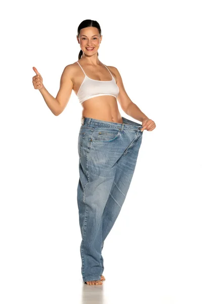 Giovane Donna Magra Pantaloni Grandi Dimensioni Mostrando Pollici Sfondo Bianco — Foto Stock