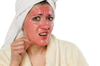 Korkmuş kadının yüz maskesi ile sorunları var.