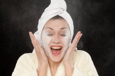 Güzel genç bir kadın yüzüne bebek pudrası sürmüş.