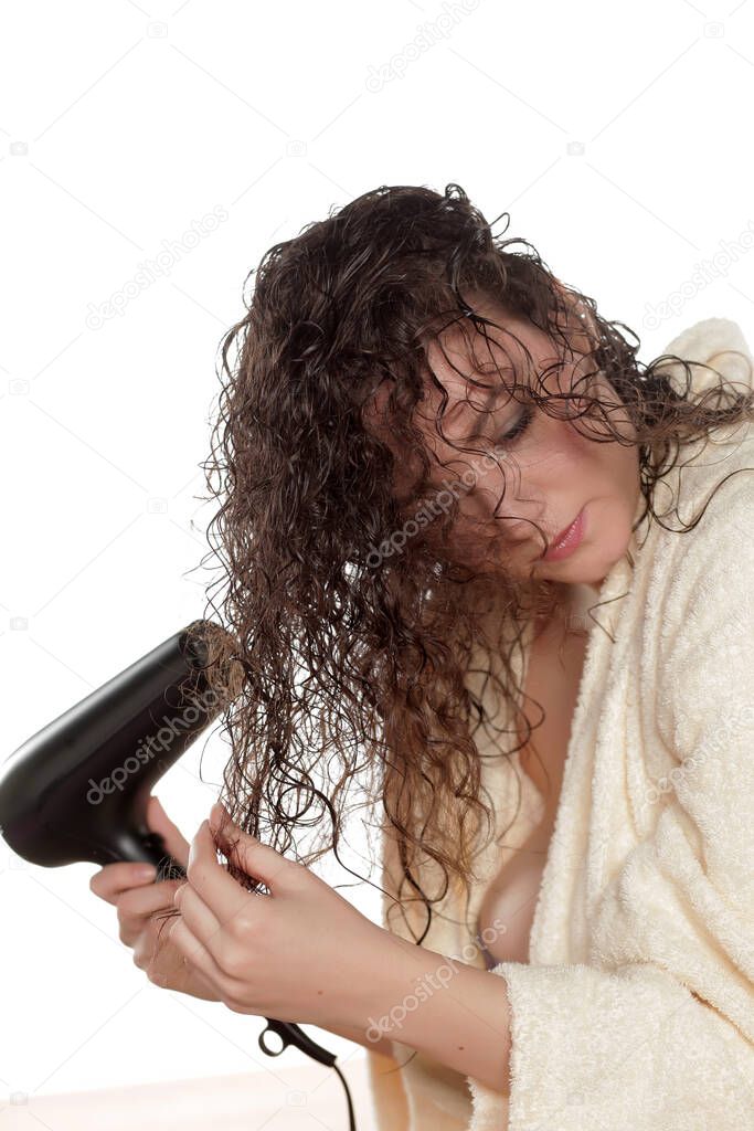young woman dries her hair with a blow dryer