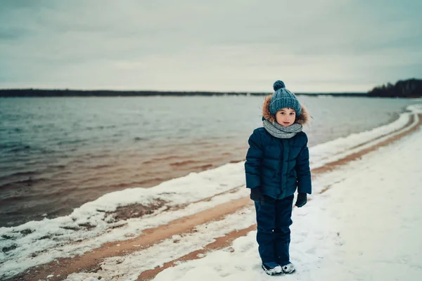 Вид Мальчика Теплой Одежде Стоящего Зимой Пляже Озера — стоковое фото