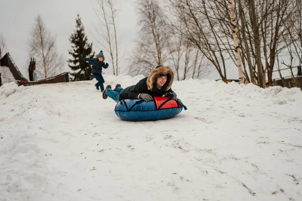 Muž Nafukovací Sněhové Trubice Sáňkování Witer Parku Zatímco Syn Běží — Stock fotografie