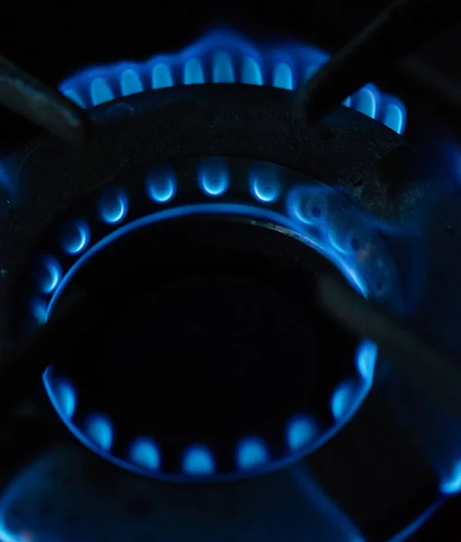 Una imagen macro de una llama azul borrosa en el quemador de la estufa de gas . — Foto de Stock
