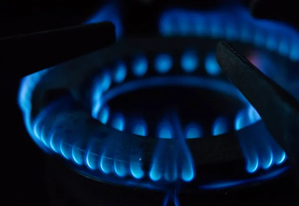 Una imagen macro de una llama azul borrosa en el quemador de la estufa de gas . — Foto de Stock