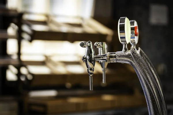 Nahaufnahme von glänzendem Bierhahn über unkonzentriertem Hintergrund an der Brauereibar. — Stockfoto