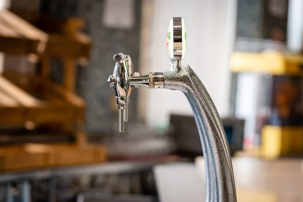 Detailní záběr lesklého kohoutku na rozostřené pozadí pivovarského baru. — Stock fotografie