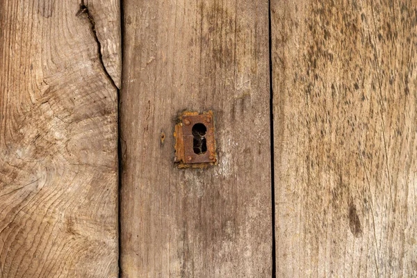 Buraco de fechadura e escudo de metal velho em uma porta de madeira grungy angustiada angustiada, vista de textura de perto — Fotografia de Stock