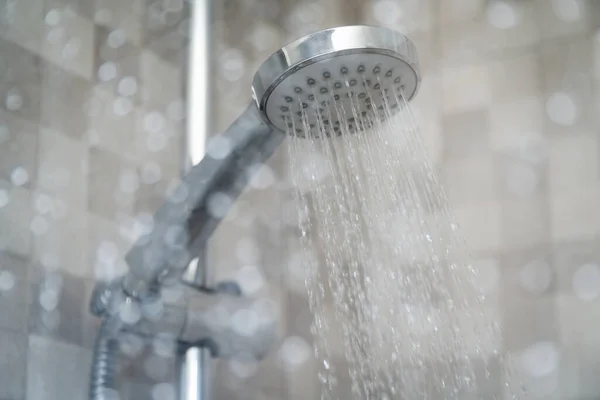 水滴が飛び散る湿式ガラス窓の後ろに新鮮なシャワー シャワーヘッドから流れる水 ストック写真