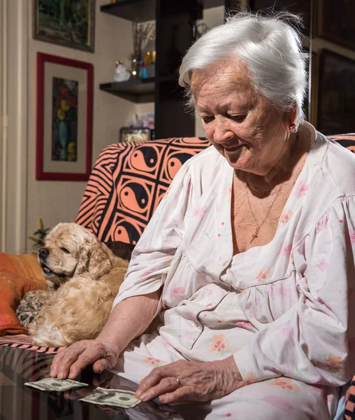 Žena při pohledu na roztržené sto dolarové bankovky — Stock fotografie