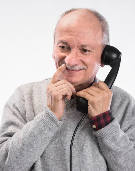 Porträtt av happy senior man pratar på gamla fast telefon — Stockfoto