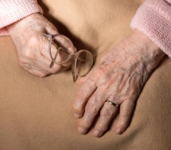 Yakın çekim yaşlı kadının el ile gözlük — Stok fotoğraf