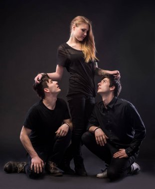 Genç kadın iki genç adamla poz