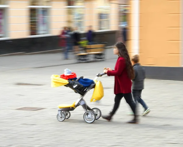 Mladá matka s malým dítětem v strolle — Stock fotografie