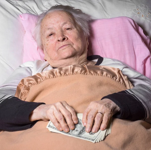 老婆のベッドで横になっていると、ドルの現金を保有 — ストック写真