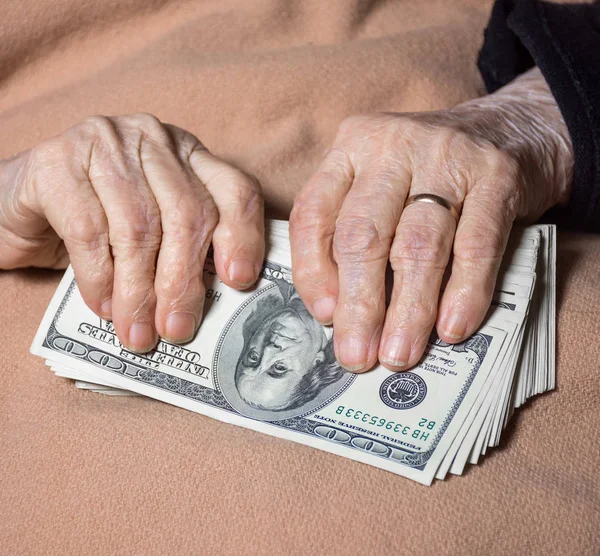 Руки старухи держат долларовые деньги — стоковое фото