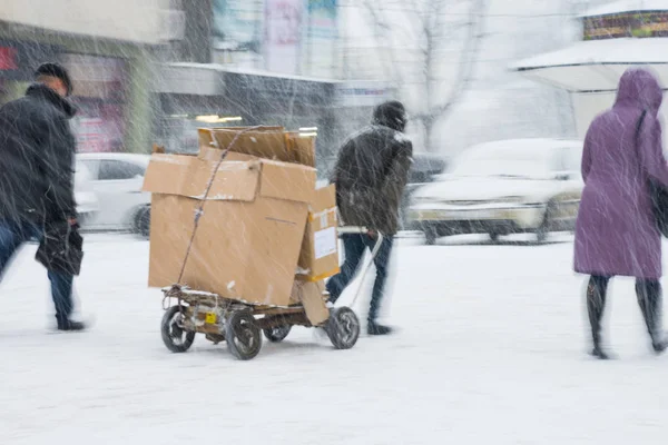 Arme man trekken van een kar met karton — Stockfoto