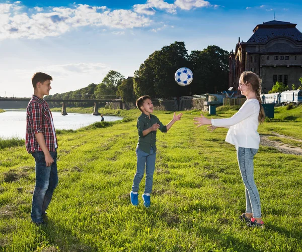 Niños felices saltando y jugando con la pelota — Foto de Stock