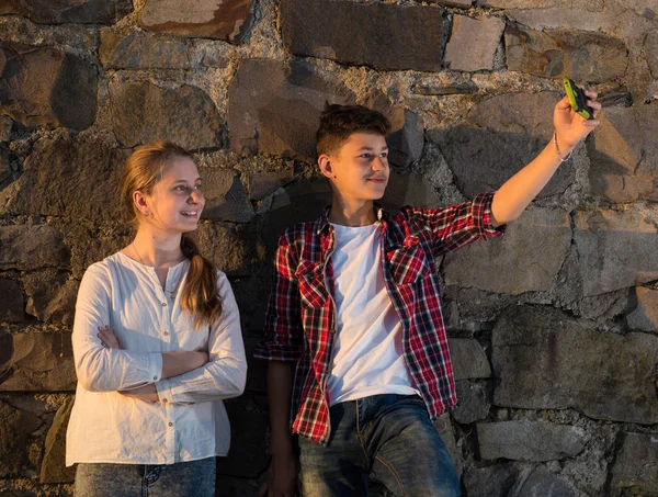 Happy smiling girl and boy taking selfies with smartphone — Stock Photo, Image