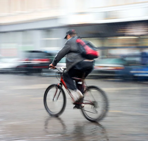 Велосипедист на проїжджій частині міста в дощовий день — стокове фото