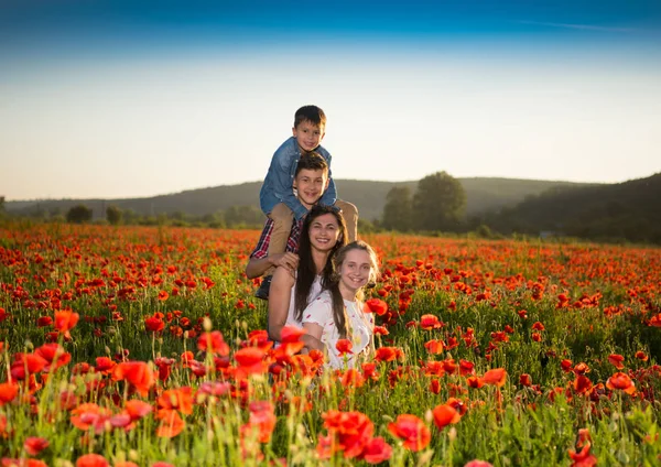 Familia feliz posando en el campo de amapola —  Fotos de Stock