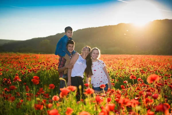 Familia feliz posando en el campo de amapola —  Fotos de Stock
