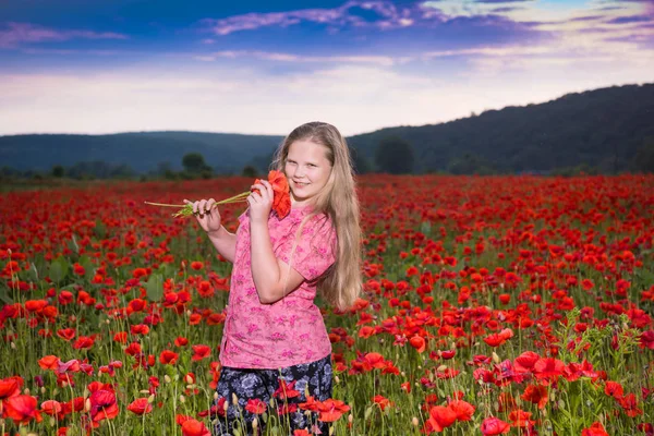 Smiling beautiful teen girl with a poppy flower — Stock Photo, Image